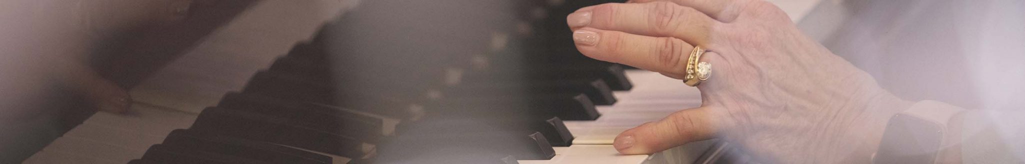 A close up photo of a senior woman playing the piano